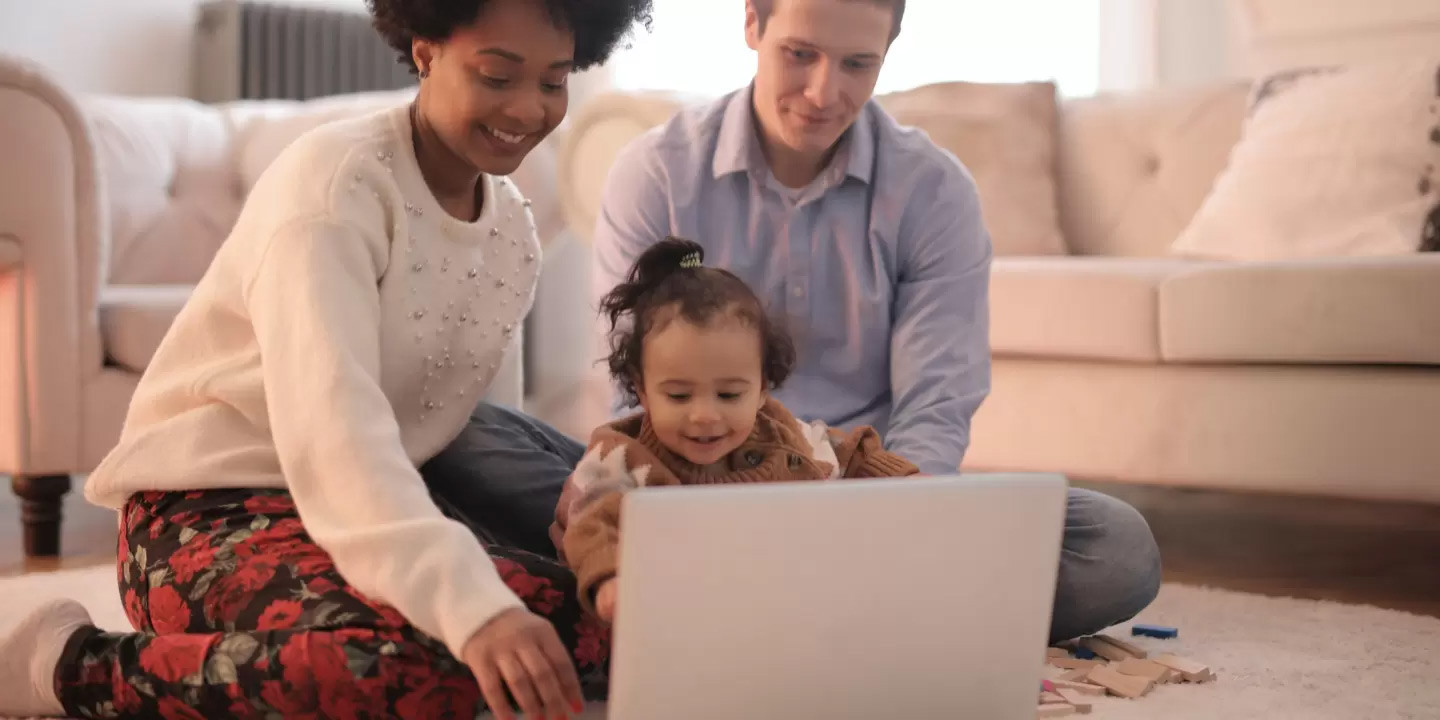 couple with baby looking into laptop