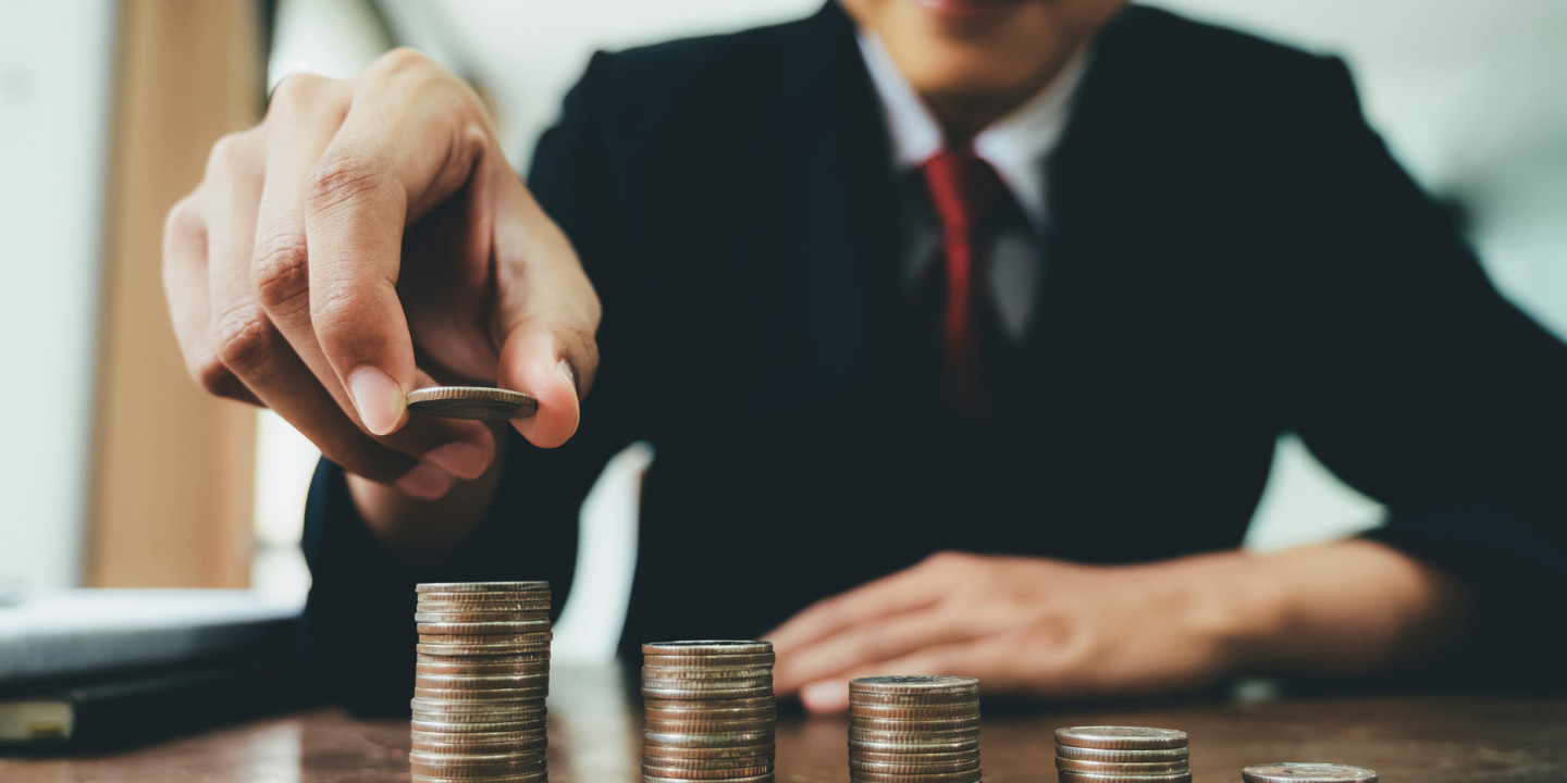 person in suit stacking coins